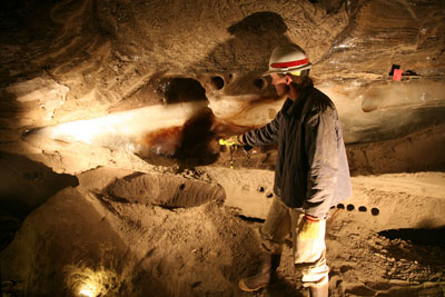 Man pointing to thermokarst-cave ice.